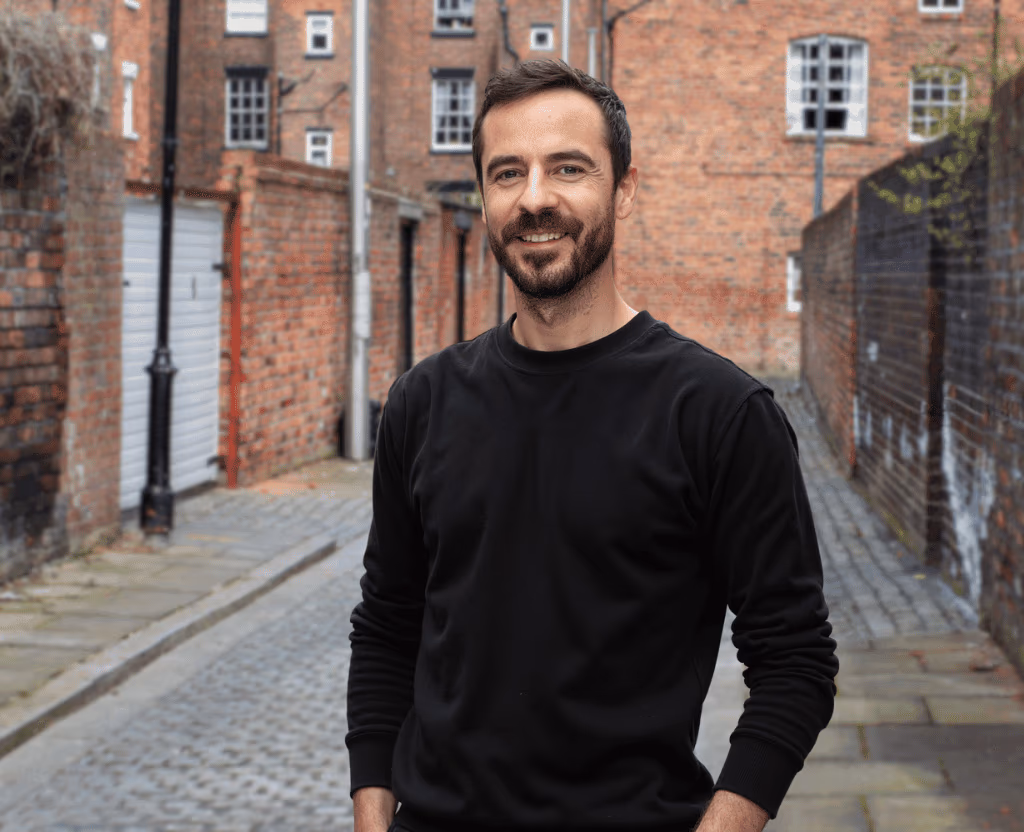 Jack Price standing in a brick-lined Liverpool street